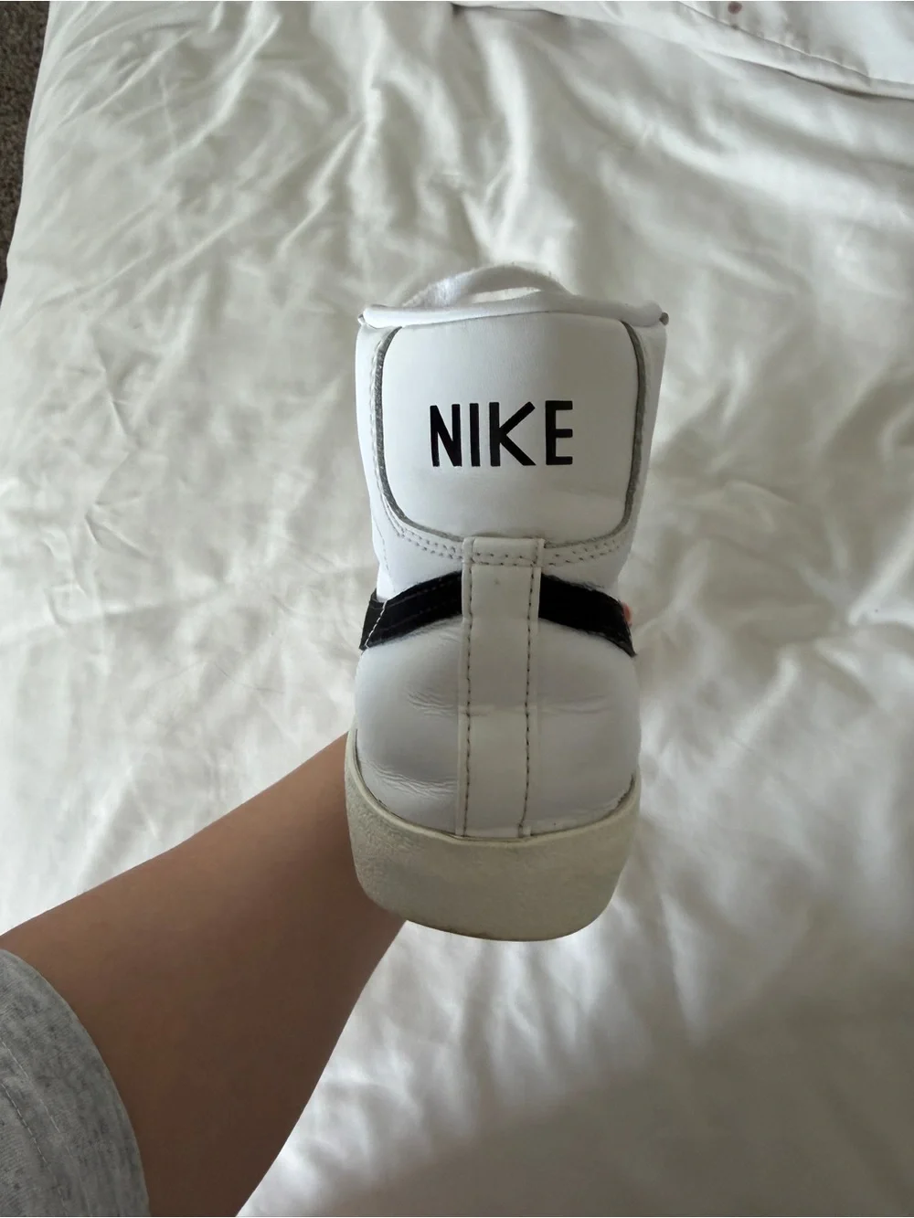 Nike White High-Top Sneakers with Black Swoosh and Orange Accent